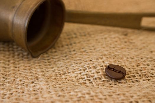 Coffee pot and coffee bean on burlap sack background