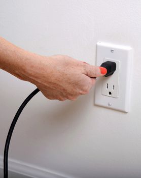 pull the plug concept with woman pulling black cord and plug