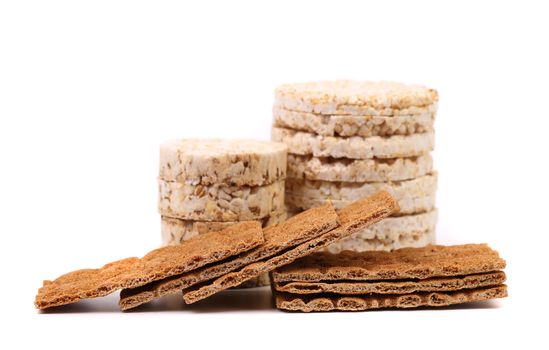 Whole grain crisp bread and puffed rice snack. White background.