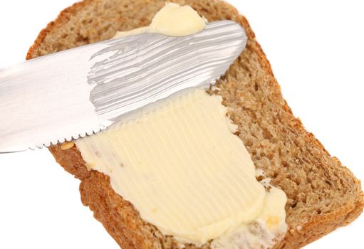 Smear butter on bread the knife. Close up.