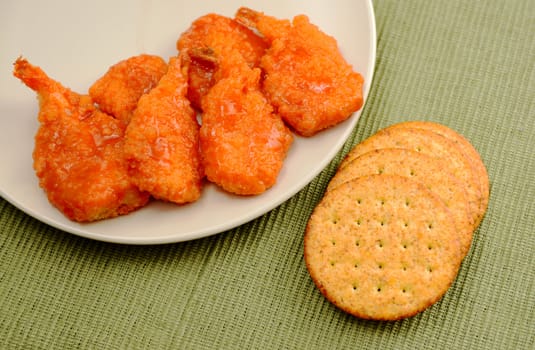 spicy fried buffalo shrimp in hot sauce with crackers