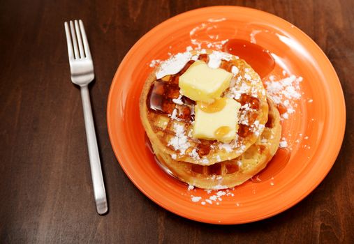 country waffles with powdered sugar, butter and syrup