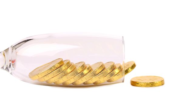 Chocolate coins get out of wineglass. White background.