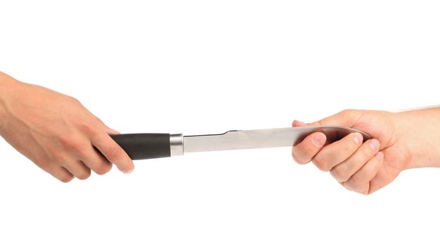Transfer the knife from hand to hand. White background.