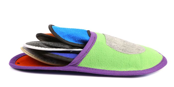 Colourful slippers into big slipper on a white background.