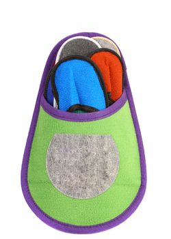 Colourful slippers into big slipper on a white background.