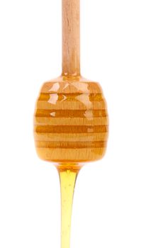 Honey dripping from a wooden honey dipper isolated on white background cutout