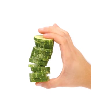 Hand holds stack of sliced cucumber. White background.