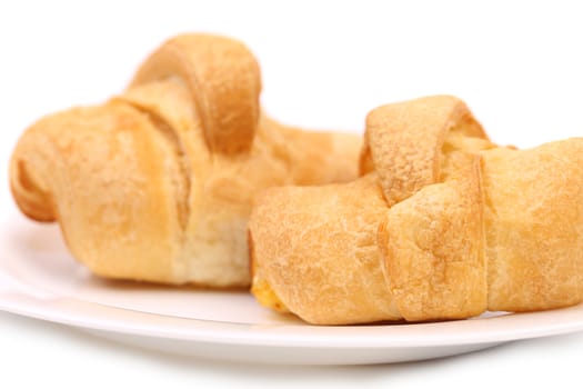 fresh croissants on white plate with powdered sugar