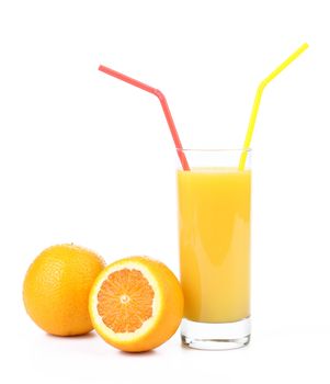 Orange juice with staw and two oranges cut and whole