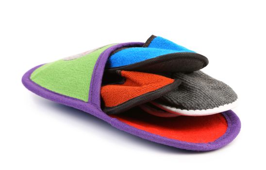 Four small slippers inside a big on a white