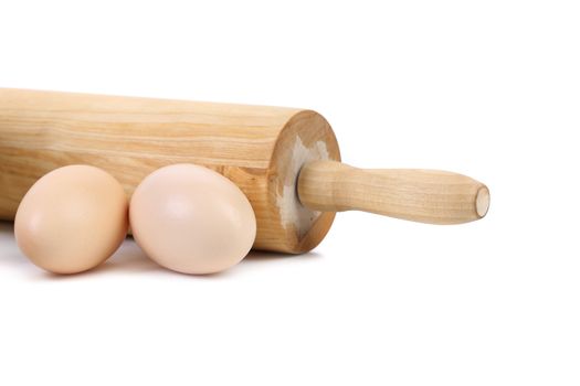 Wooden rolling pin with two chicken eggs