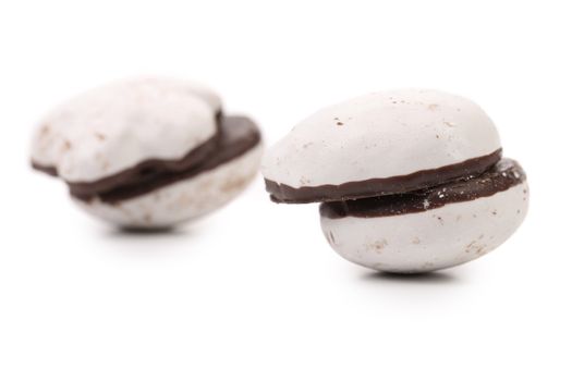 Two couple of chocolate meringues. White background.