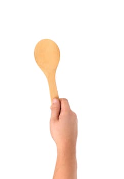 Hand holds wooden spoon. Isolated on a white background.