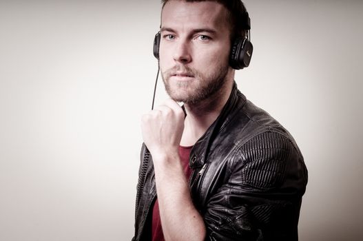 stylish hipster listening to music on gray background