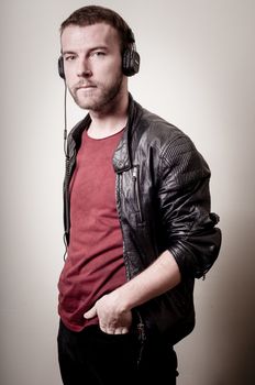 stylish hipster listening to music on gray background