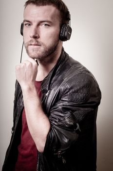 stylish hipster listening to music on gray background