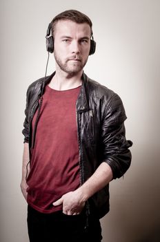 stylish hipster listening to music on gray background