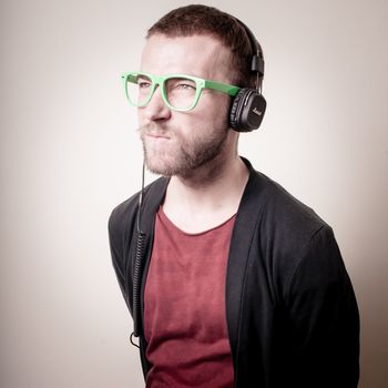 stylish hipster listening to music on gray background