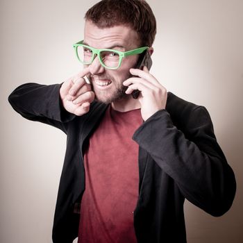 funny stylish hipster man on the phone on gray background