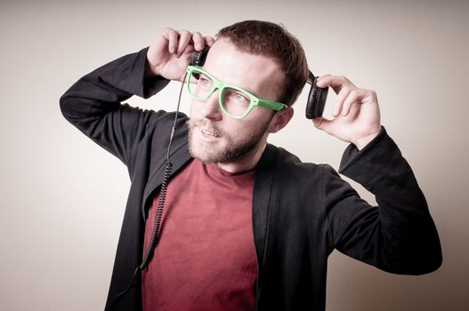 stylish hipster listening to music on gray background