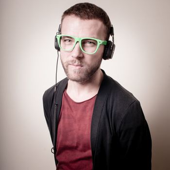 stylish hipster listening to music on gray background