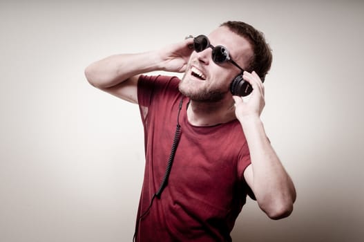 stylish hipster listening to music on gray background