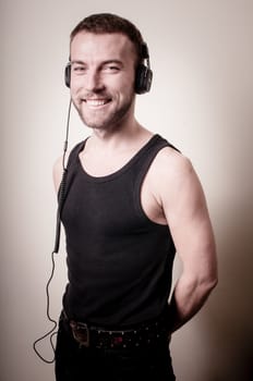 stylish hipster listening to music on gray background