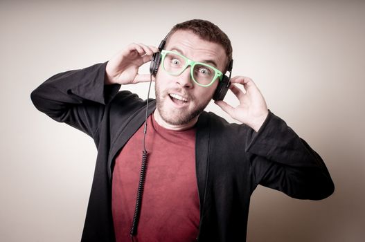 stylish hipster listening to music on gray background