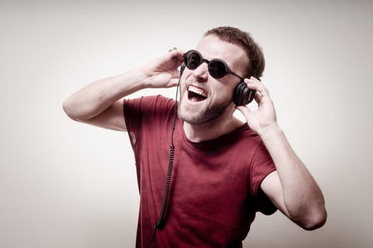 stylish hipster listening to music on gray background
