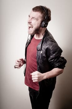 stylish hipster listening to music on gray background
