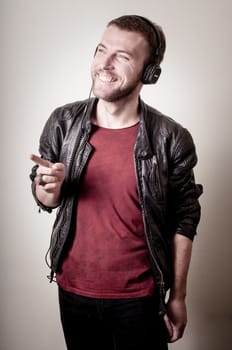 stylish hipster listening to music on gray background