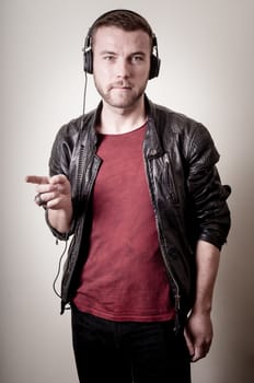 stylish hipster listening to music on gray background