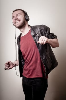 stylish hipster listening to music on gray background