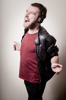 stylish hipster listening to music on gray background