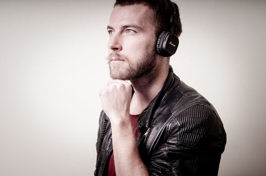 stylish hipster listening to music on gray background