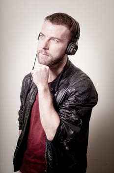 stylish hipster listening to music on gray background
