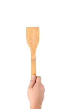 Hand holds woodfen spatula. Isolated on a white background.