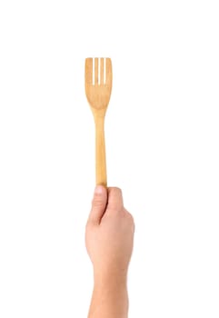 Hand holds woodfen spatula. Isolated on a white background.