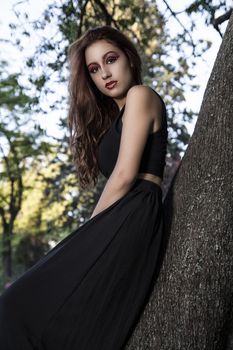 Girl in a tree. Beautiful Teenage Model Dressed in Fashionable Short Dress. Beauty Romantic Girl Outdoor. Toned in warm colors. Fashion Look