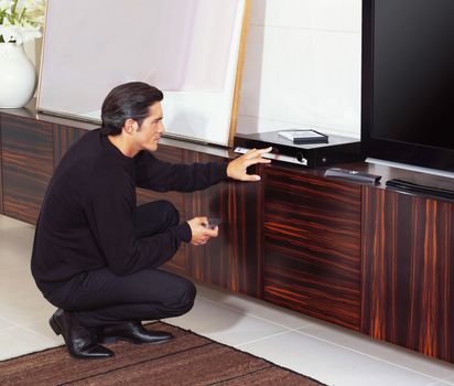 man using dvd player in living room