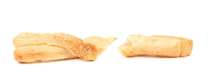 Puff pastry sticks with sesame seeds on white background
