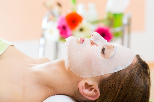 Wellness - woman receiving facial mask in spa for clean skin