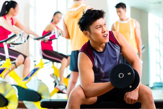 Chinese Asian group of men and woman doing sport exercise or training in fitness gym with barbell weights for more power