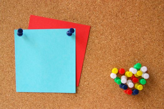 Corkboard with pushpins as heart and notes