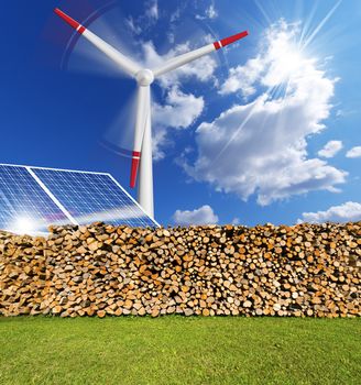 Solar panels, firewood logs in a pile and a turbine power station - renewable energy