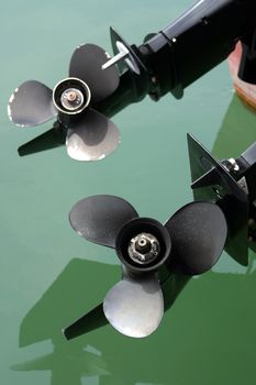 Boat propellers on green clear watter