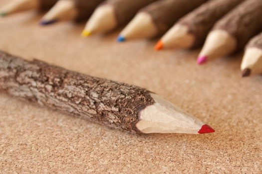 Colored pencils on brown cork background