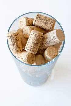 Wine cork in a glass on white background