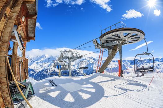Ski lift chairs and sun on bright winter day 